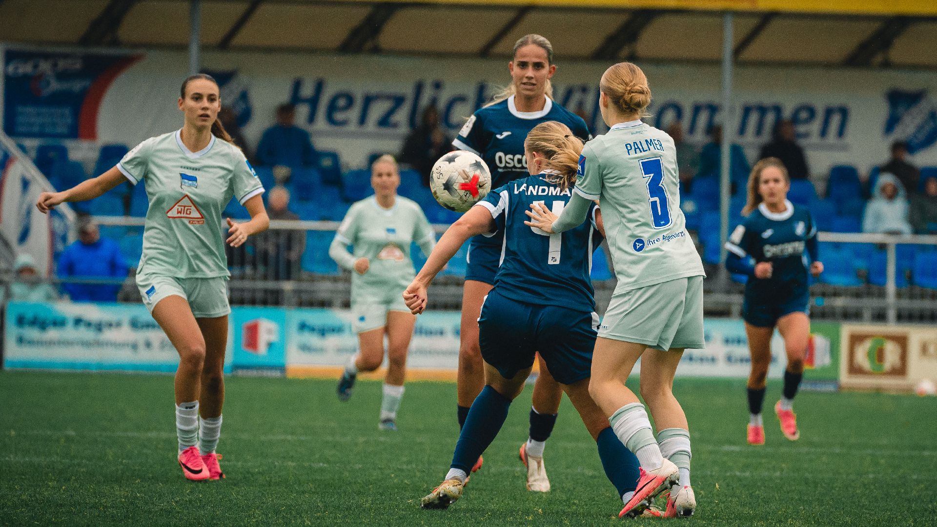 Nelly Palmer im Zweikampf mit zwei Gegenspielerinnen von Sand.